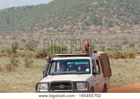 SAMBURU NATIONAL RESERVE KENYA - NOVEMBER 27 2016: A Samburu safari guide looking for animals for a visitor on an open top safari vehicle