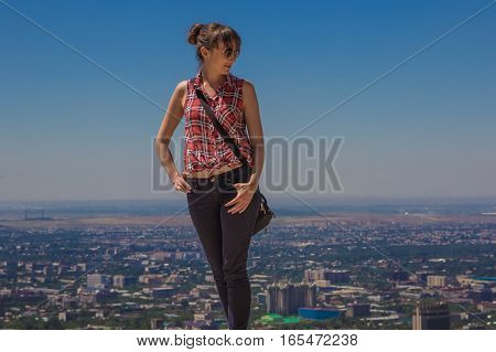 Young woman staing on the hill with city view Almaty Kazakhstan 2016