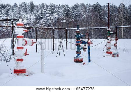 Wellhead valve. Oil and gas concept. Industrial site during winter period.