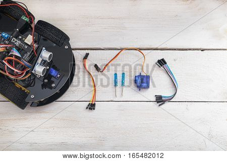 robot elements. Servo screwdriver lying on a wooden table. view from above