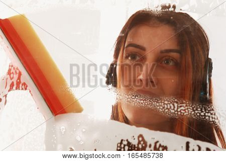Woman at work professional female cleaner cleaning and wiping window in office