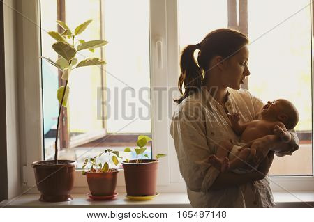 photo of young mother with baby at home