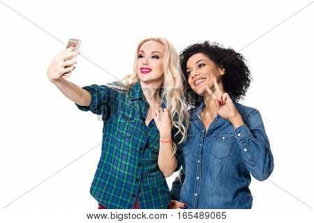Two beautiful girls making selfie. Isolated on white background