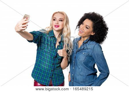 Two beautiful girls making selfie. Isolated on white background