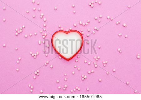 white with a red heart on a pink background with confectionery decoration. romantic love background for Valentine's day birthday holiday party wedding.