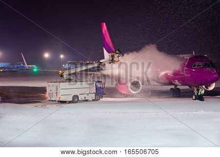 Deicing Passenger Airplane During Heavy Snow