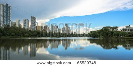 Lake reflecting on the water the city and the blue sky. Margins of the lake Igapo in Londrina PR Brazil.