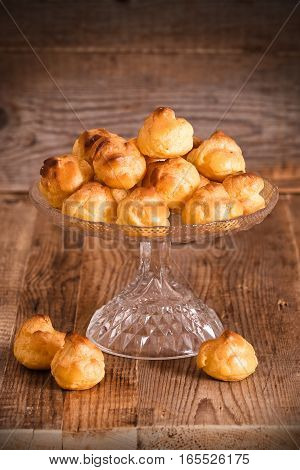 Group of sweet cream puffs on glass tray.