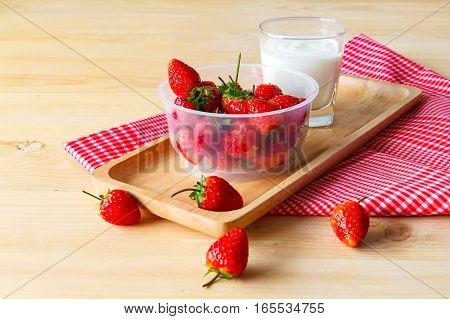 focus fresh strawberry in cup. Paste with yogurt on the wooden background.
