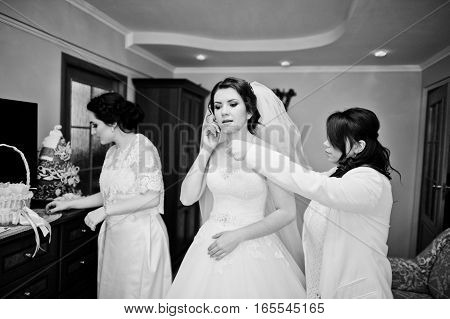 Bridesmaids Helping Dressed Bride On Wedding Day At Morning. Black And White Photo
