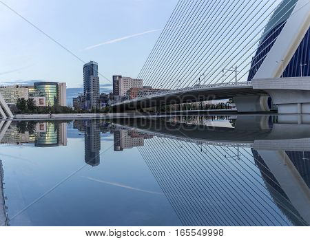 Valencia, Spain - December 20, 2016: old dry riverbed of the River Turia, Gigapan reflection in the water of a bridge, Office buildings and shopping. Europe