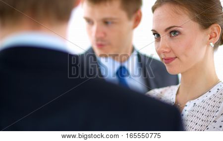 Businesswoman writing on flipchart while giving presentation to colleagues in office .