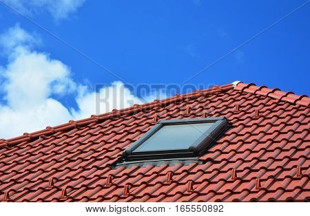 Skylight on red ceramic tiles house roof. Skylights, Roof Windows and Sun Tunnels.