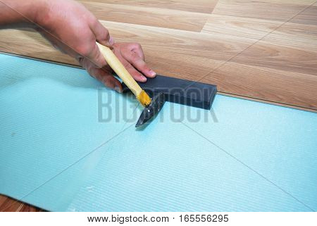 Man Installing New Laminate Wood Flooring. Worker Installing wooden laminate flooring. Step by Step.