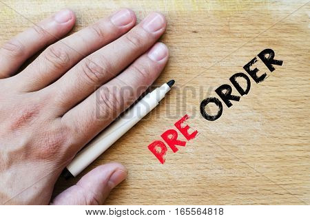Human hand over wooden background and pre order text concept