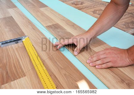 Contractor laying laminate flooring. Installing wooden laminate flooring. Step by Step.