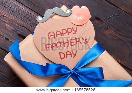 Gift box on Father's Day. Greeting card, ribbon bow, props. Express gratitude to dad.