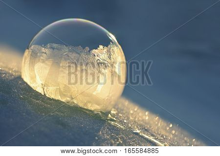 Frozen soap bubble. Cold winter liquid ball experiment. Freezing water with icy patter texture