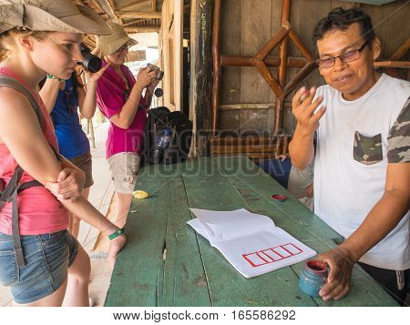 Santo Tomas Peru - May 17 2016: Peruvian man showing the calligraphy to the tourists