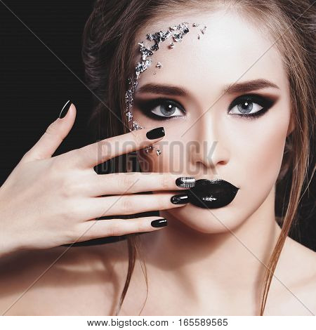 Beauty Woman Portrait. Professional Makeup and Manicure with siver foil glitter, smokey eyes. Black colors. Copy-space. Pastel toned