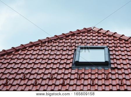 Attic skylight window on red ceramic tiles house roof outdoor. Attic Skylights Home Design Ideas Exterior. Roofing Construction.