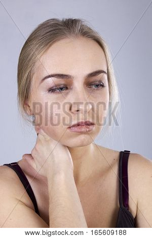 Portrait of a young woman in a gloom on the gray background. Seven Deadly Sins