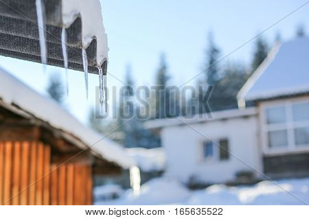 Close-up With Icicles On A Wooden Mountain House On A Sunny Day