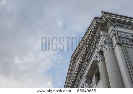 It soars into the clouds building with columns and blue sky