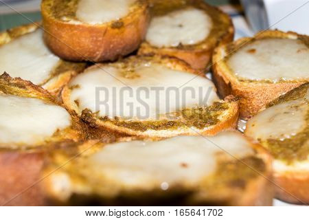 slices of toasted bread season with olive paste and melted cheese