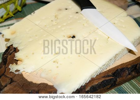 Cutting board with slice of pecorino cheese