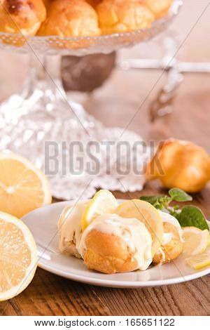Lemon Profiteroles with custard cream on white dish.