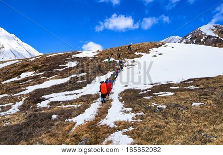 MUNCH-SARDYK BURYATIA RUSSIA - April 30.2016: Climbers on hillside in front of approach to foot of mountain. Active holidays in Eastern Sayan