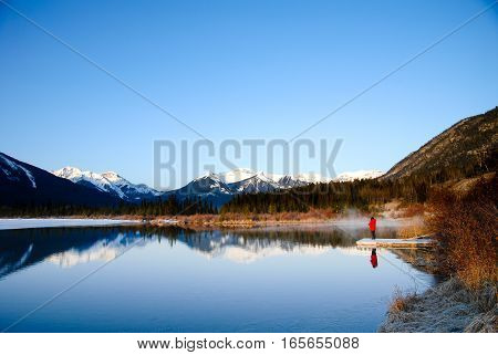 Woman on the Side of Vermilion Lake at Dawn in Winter Canadian Rockies Alberta Canada