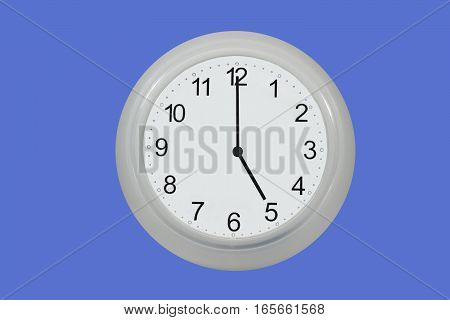 Wall watch showing five o'clock isolated on blue background
