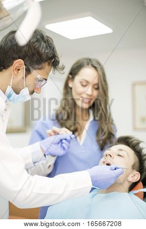 Young Man Having Dental Chekup At Dentist Office