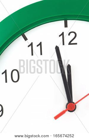 Almost twelve o'clock on big wall clock isolated on white vertical close up