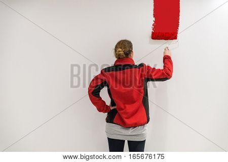 Female Painter With Paint Roller In Front Of Wall As Template