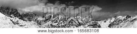 Black And White Large Panoramic View On Snow Mountains In Haze At Sunny Day