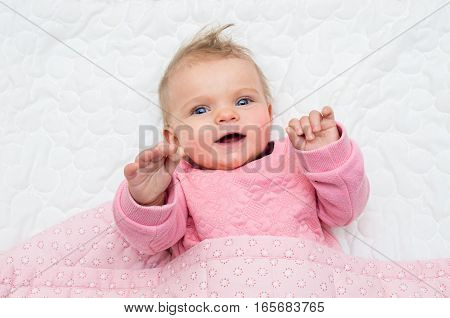 Happy Infant Baby Girl Smiling On Bed