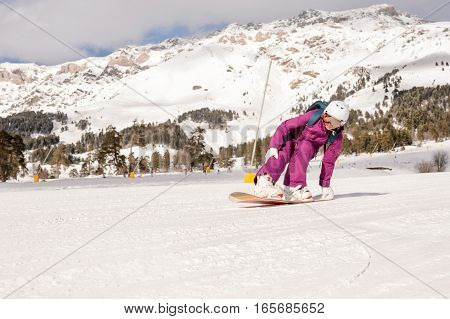 Beautiful beginner snowboarder girl in caucasian mountains