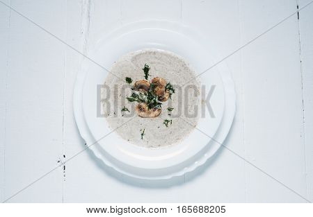 Bowl of creamy mushroom soup on wood.