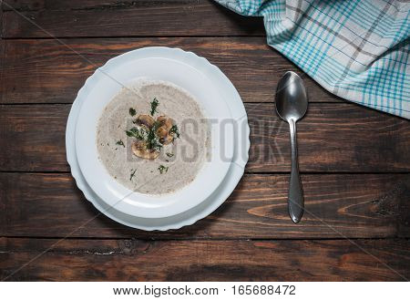 Bowl of creamy mushroom soup on wood.