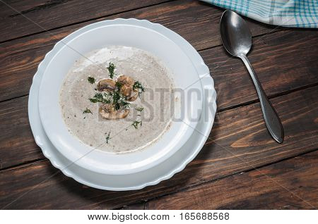 Bowl of creamy mushroom soup on wood.