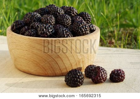 fresh black raspberries in the wooden cup