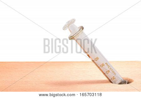 glass insulin syringe on a wooden background on the division syringe for definition of a dose