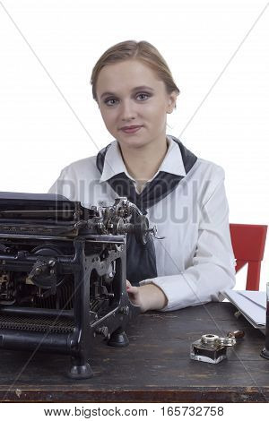 Young girl typist with an old typewriter on a white background