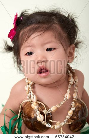Cute Asian Chinese baby girl dressed in Hawaiian outfit.
