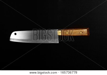 Old knife with brown handle isolated on a black background