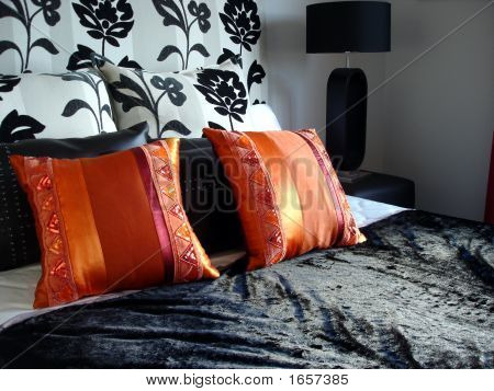 Oranžové polštáře na černém postel