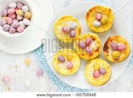 Easter nest cakes with chocolate candy eggs on festive Easter table Easter holiday recipe